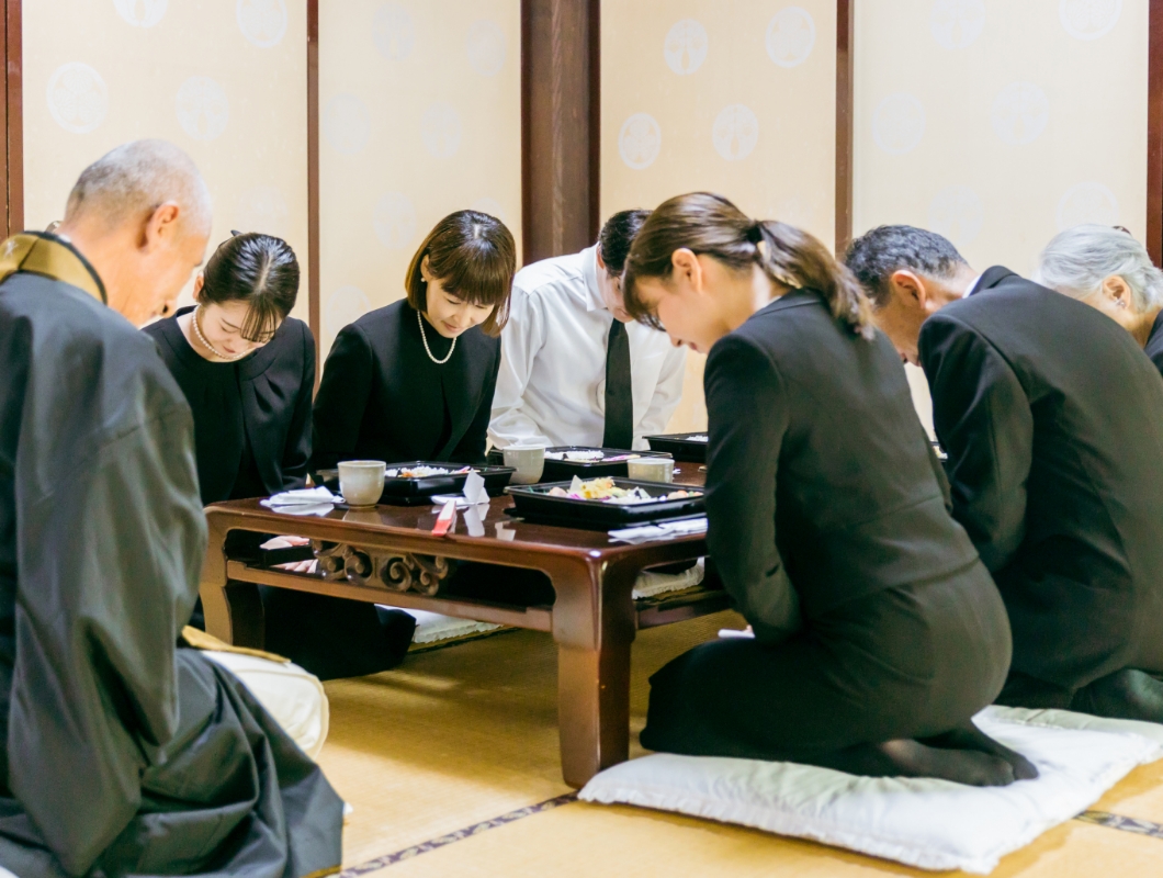 喪服で食事する人々